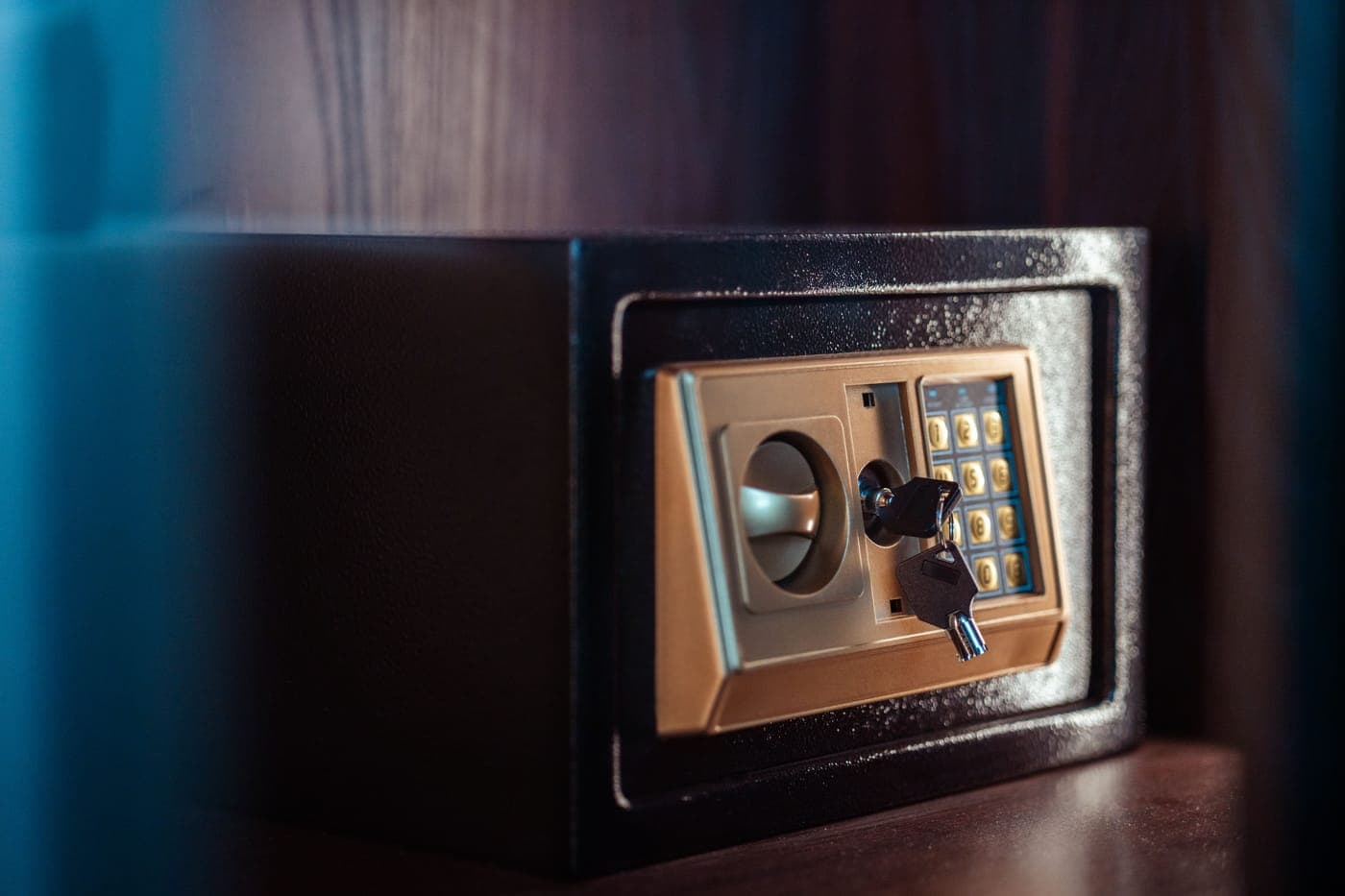 Close-up of an electronic safe door with a keypad and a key in the lock