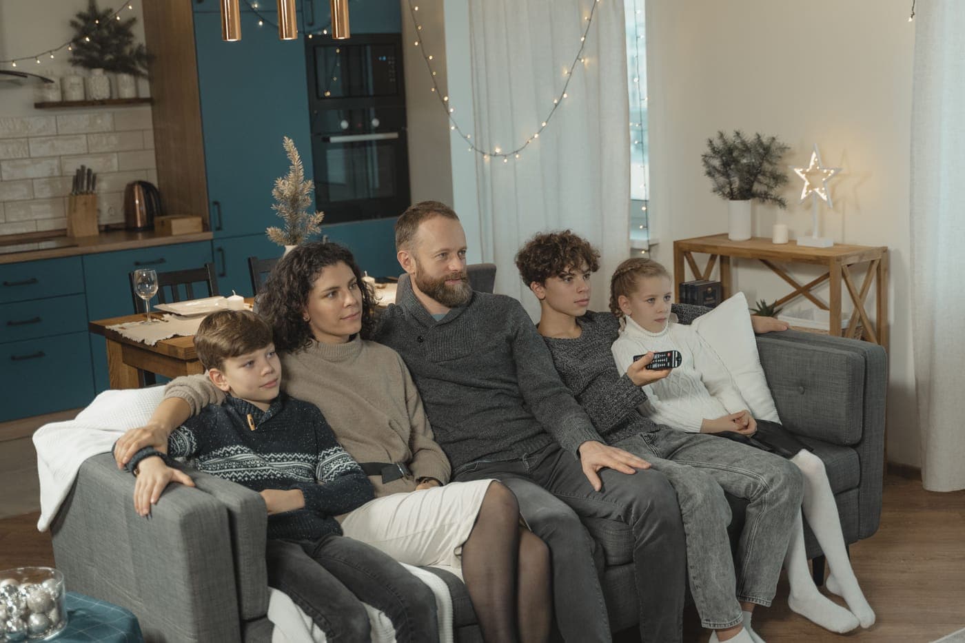 A family of five relaxing together on a couch at home