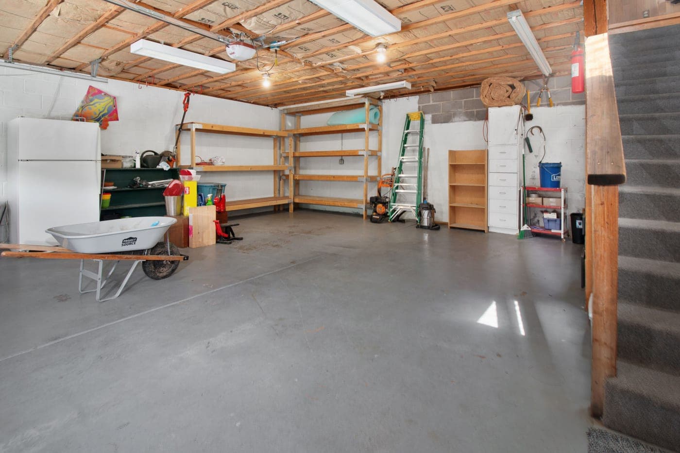 A home garage with storage shelves, tools and a concrete floor