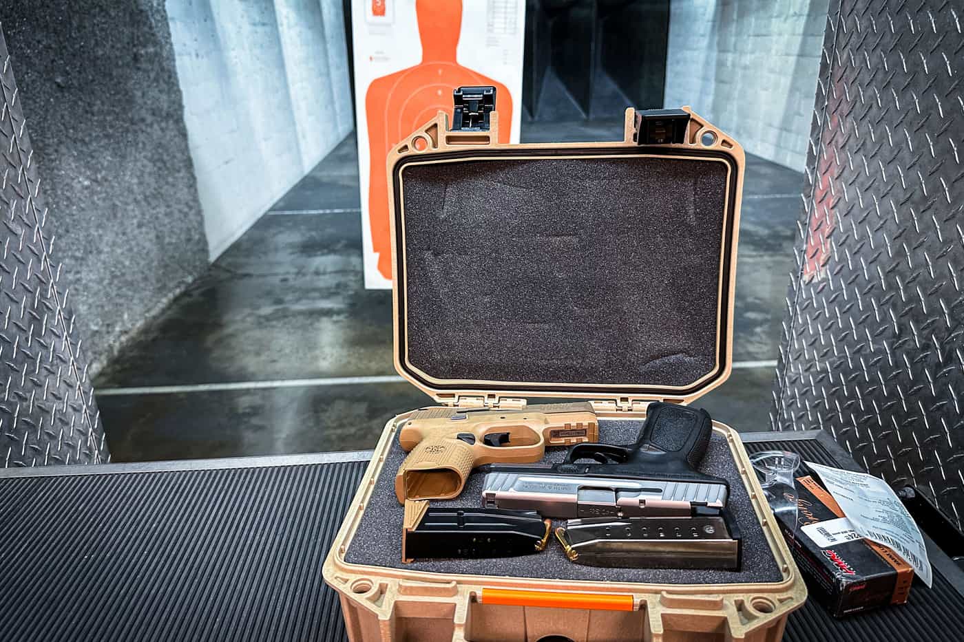 An open hard case holding a handgun and accessories