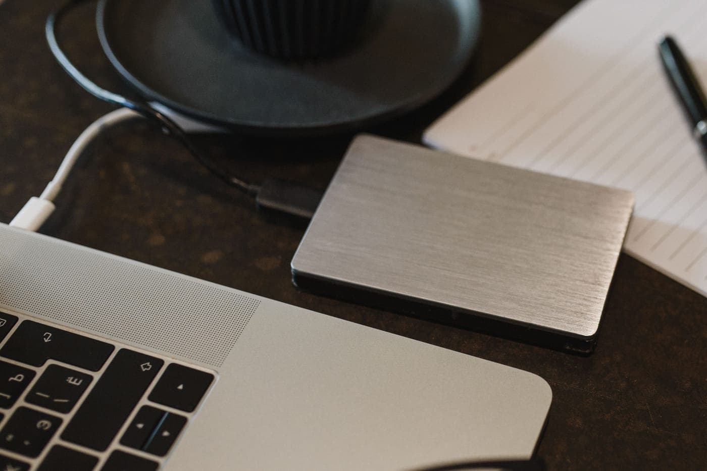 An external hard drive connected to a laptop by a USB cable