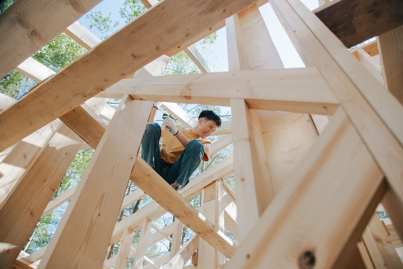 A carpenter working on the wooden frame of a house