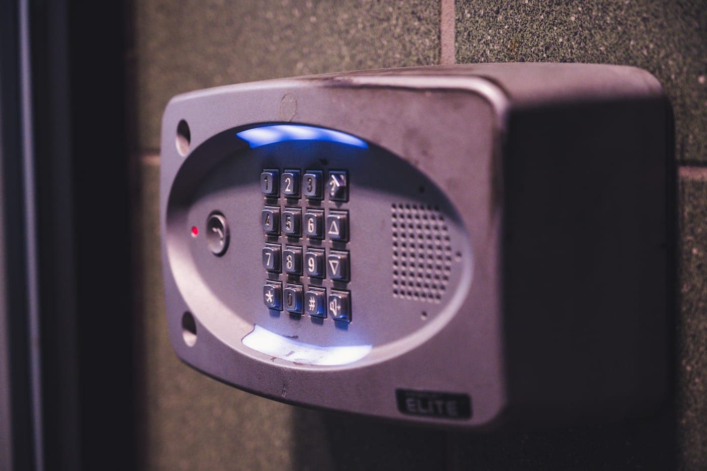 An illuminated security keypad mounted on a wall