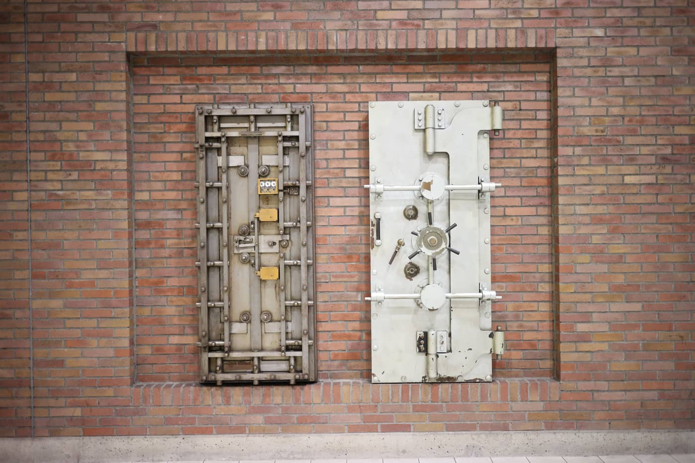 Two heavy steel vault doors set into an old brick wall
