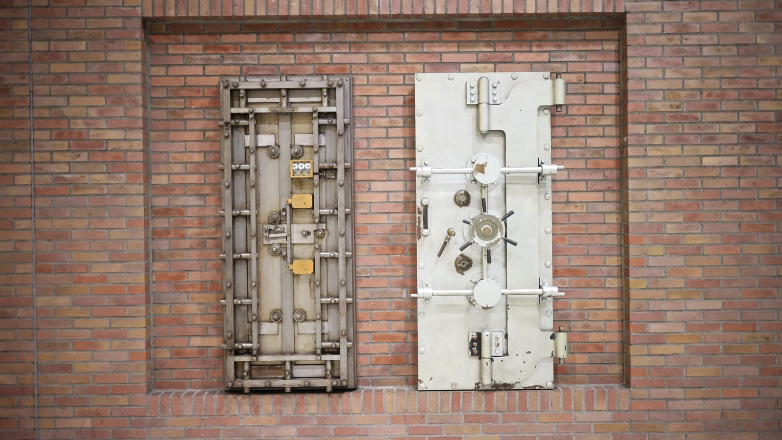 Two heavy steel vault doors set into an old brick wall