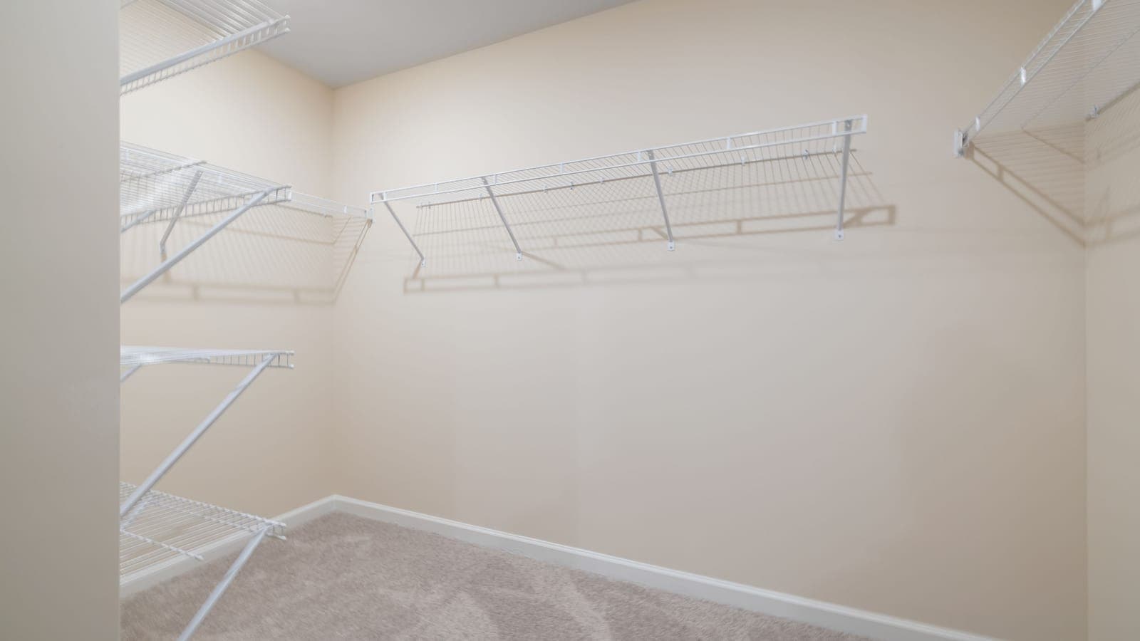 An empty walk-in closet with wall-mounted wire shelving